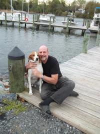 man and dog by water